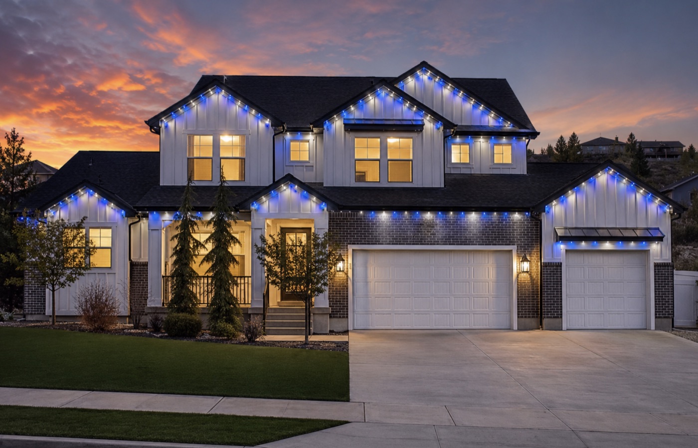 Two-story home with its roofline lit blue and white for game day